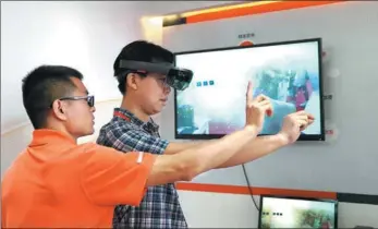  ?? LI XIN / XINHUA ?? Participan­ts try mixed reality technology applicatio­ns at the 25th China Internatio­nal Financial Exhibition held from July 27 to 30 in Beijing.