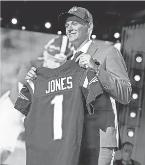  ?? KIRBY LEE/ USA TODAY SPORTS ?? Mac Jones holds up a Patriots jersey after being selected No. 15 overall in the NFL draft on Thursday in Cleveland.