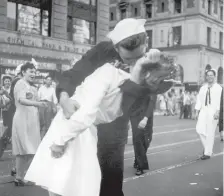  ?? AP PHOTO/ VICTOR JORGENSEN ?? George Mendonsa and Greta Zimmer Friedman kiss in New York’s Times Square, Aug. 14, 1945, as people celebrate the end of World War II. The ecstatic sailor died Sunday. Mendonsa was 95.