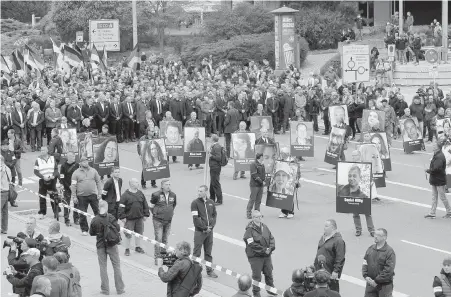  ??  ?? Demonstrat­ors, holding photos of people they claim have been killed by migrants, march in Chemnitz, eastern Germany, on Saturday.