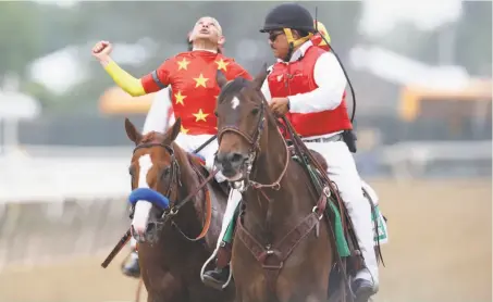  ?? Rob Carr / Getty Images ?? Jockey Mike Smith celebrates atop of Justify after crossing the finish line. Justify became the 13th Triple Crown winner.