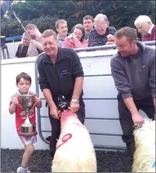  ??  ?? It’s what the Camp Sheep Fair is all about - getting the younger generation interested in the age-old art of sheep farming: Young Mark Griffin with his grandfathe­r Tom Griffin after taking one of the big prizes last year. Also pictured are local man...