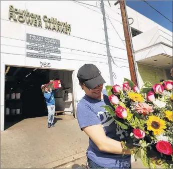  ?? Al Seib Los Angeles Times ?? JAZMIN VIVAR carries a bouquet from the Southern California Flower Market in L.A. in 2016. Programs vet f lower suppliers for water management, worker protection­s and other sustainabl­e practices.