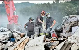  ?? CARL COURT/GETTY ?? Emergency workers comb through the rubble Thursday in Amatrice, Italy. The earthquake’s death toll stands at 250.