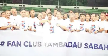  ??  ?? Liawas presenting a T-Shirt to Peter during the launching ceremony of the Sabah Tambadau Fan Club at the Likas Stadium on Tuesday.