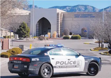  ?? JIM THOMPSON/JOURNAL ?? An Albuquerqu­e police car blocks an entrance to the Jewish Community Center of Greater Albuquerqu­e after a bomb scare led to an evacuation. The community center was one of many targeted across the country Tuesday.