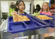  ?? LISA RATHKE - THE ASSOCIATED PRESS ?? Students get lunch of homemade pizza and caesar salad at the Albert D. Lawton Intermedia­te School, in Essex Junction, Vt., June 9. The pandemic-era federal aid that made school meals available for free to all public school students — regardless of family income levels — is ending, raising fears about the effects in the upcoming school year for families already struggling with rising food and fuel costs.