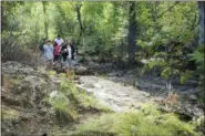  ?? THE ASSOCIATED PRESS ?? A group of people who identified themselves as relatives of the missing man walk along the riverbank, not far from where one body was recovered in Tonto National Forest, Ariz., Monday, July 17, 2017.