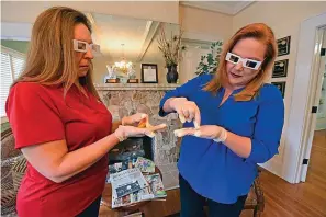  ?? The Dothan Eagle via Associated Press ?? ■ Nancy Griffin, left, and Liz Woodard use impaired goggles and gloves to simulate sensory loss in eyesight and touch on March 11 at Home Instead Senior Care in Dothan, Ala. As one of the caregivers with Wiregrass Area Home Instead Senior Care looking after a man and his wife, Griffin sees the challenges people with sensory loss face.