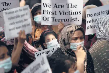  ?? MANISH SWARUP/AP ?? Afghan refugees markWomen’s Day in India: Afghan refugee women living in India hold placards during a demonstrat­ion Monday to mark Internatio­nal Women’s Day in New Delhi. The Afghan women were calling attention to their living conditions and requesting more support from the United Nations and the Indian government.