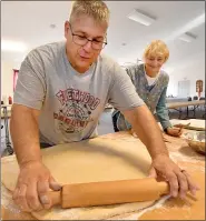  ??  ?? Craig Conrad rolls out the raised dough while Willie Schaeffer watches Saturday at Friedens United Church of Christ in Oley. Both are Oley Township residents.