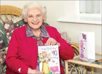  ??  ?? Noreen Talbot sitting in her porch with a couple of her 90th birthday cards.