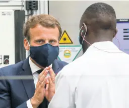  ??  ?? French President Emmanuel Macron wears a face mask as he speaks to a worker during a visit at the Valeo manufactur­er plant in Etaples, northern France, on Tuesday, May 26, 2020.