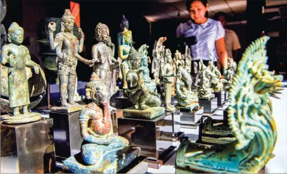  ?? TANG CHHIN SOTHY/AFP ?? Artefacts are displayed during a ceremony in which 85 items were returned to the National Museum in Phnom Penh last weekend. They had been displayed in a Japanese antiques collector’s home for two decades. The Ministry of Culture and Fine Arts said some items dated prior to the Angkor era, which began around 800 AD.