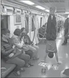  ?? DAI BING / FOR CHINA DAILY ?? Gymnast Zhang Shangwu performs in a subway car.