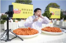  ?? — Reuters ?? An employee eats snacks during a live-streaming promotion at the snacks maker’s factory in Hunan province, China, on Sunday.