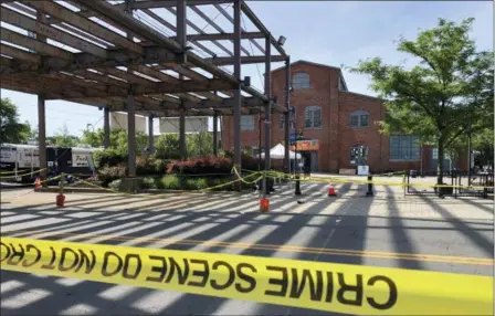  ?? MIKE CATALINI — THE ASSOCIATED PRESS ?? Police crime-scene tape keeps people away from the brick Roebling Wire Works building, background, in Trenton, N.J., hours after a shooting broke out there at an all-night art festival early Sunday sending people stampeding from the scene, leaving one suspect dead and at least 20 people injured.