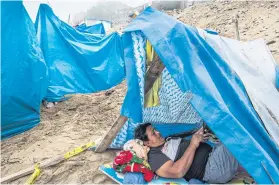  ??  ?? Rafael Córdova, an unemployed father of three, with his family at squatter’s camp in Lima, Peru.