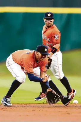  ?? Karen Warren / Houston Chronicle ?? Astros shortstop Carlos Correa fields Mike Trout’s grounder during the first inning Saturday. Correa aggravated a shoulder injury in Friday’s loss to the Angels but was back out on the field Saturday at Minute Maid Park.