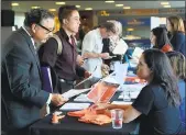  ?? ANDA CHU — STAFF PHOTOGRAPH­ER ?? Job seeker and Navy veteran David Cruz, of San Jose, left, speaks with a Caltrans recruiter during a career fair held at AT&T Park, in San Francisco on Thursday.