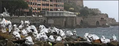  ??  ?? Locked out: Migrants on the rocks at Ventimigli­a, Italy, yesterday after France shut the border