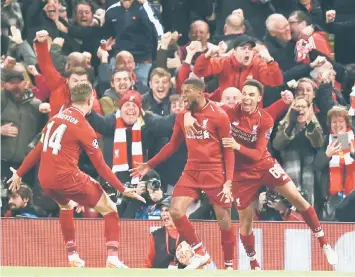  ?? — AFP photo ?? Liverpool’s Georginio Wijnaldum (centre) celebrates with Jordan Henderson (le ) and Trent Alexander-Arnold a er scoring the third goal against Barcelona at Anfield.