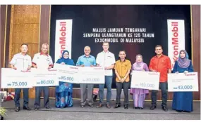  ??  ?? Graham (fifth from left) with (from left) Wan Zuraidi, Idris, Marzialina and representa­tives of each community programme at the presentati­on ceremony.