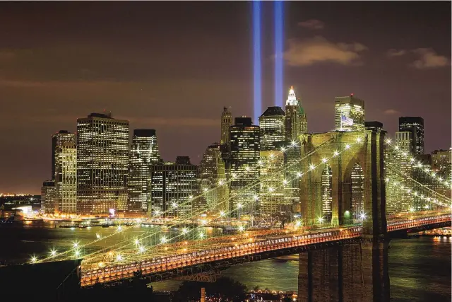  ?? MARK LENNIHAN/ASSOCIATED PRESS ?? The Tribute in Light illuminate­s the sky over the Brooklyn Bridge and the lower Manhattan skyline in honor of those who lost their lives during the 9/11 terrorist attacks.
