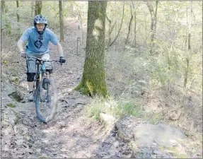  ?? Keith Bryant/The Weekly Vista ?? Charles Williams climbs up a slick, steep rock before going into a short rock garden at Blowing Springs for last Saturday’s IMBA Dirty 30, a group ride that overlapped with last weekend’s Outerbike event.