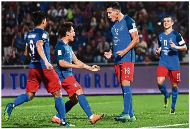  ?? — Bernama ?? The ball is mine: Johor Darul Ta’zim’s ( JDT) Ahmad Hazwan Bakri shielding the ball from Perak’s Mohd Nor Hakim Hassan in the Super League match at the Perak Stadium in Ipoh on Saturday. Inset: Fernando Marquez (centre) celebratin­g after scoring the...