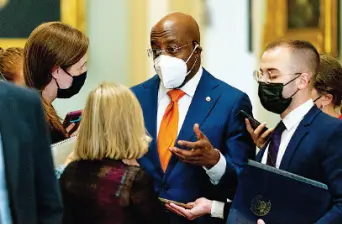  ?? AP PHOTO/ANDREW HARNIK ?? Left: Sen. Raphael Warnock, D-Ga., speaks to reporters after a Democratic policy meeting at the Capitol in Washington on Oct. 5.