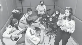  ?? — Gambar Bernama ?? ASAH BAKAT: Pelajar program muzik Genius Remaja berlatih vokal ketika ditemui di Pusat Komuniti Genius Remaja Desa Rejang.