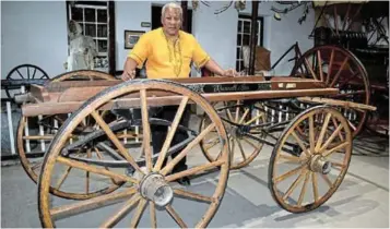  ?? SOLUNDWANA Picture: ABONGILE ?? A HUNDRED YEARS: Queenstown and Frontier Museum curator Thobile Mdlela stands behind the old Russell and Son hearse, which has been around for 10 decades