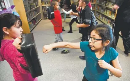  ?? Andy Cross, The Denver Post ?? Pennington Elementary School students Naiomi Padilla, 8, left, and Mariann Jaime, 9, take part in a karate class after school this month. The school this fall will become Pennington Expedition­ary School.