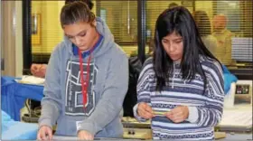  ?? MARIAN DENNIS — DIGITAL FIRST MEDIA ?? Students fromPhoeni­xville Area High School stay focused on their task as they work to arrange surgical equipment in the proper order during a workshop at Montgomery County Community College.