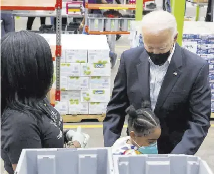  ?? JONATHAN ERNST / REUTERS ?? Biden abraza a una niña durante la visita que efectuó ayer a un banco de alimentos en Houston.