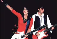  ?? PAUL NATKIN/WIREIMAGE.COM ?? Rock legend Joan Jett (left, with Kasim Sutton) takes the stage at Chicago’s Holiday Star Theater in 1985. Jett is the focus of the documentar­y “Bad Reputation.”