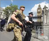  ?? Associated Press ?? A member of the army joins police officers in Westminste­r, London, on Wednesday. Britons found find armed troops at vital locations Wednesday after the official threat level was raised to its highest point following a suicide bombing that killed more...