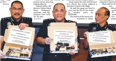  ?? – BERNAMAPIX ?? Huzir (centre) and his colleagues showing the seized firearms in Bukit Aman yesterday.