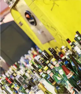  ??  ?? BOTTLE BANK. A recycling container is emptied of its contents at a recycling plant.