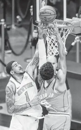  ?? Jon Shapley / Staff photograph­er ?? Knicks forward Obi Toppin, left, grabs some jersey while blocking a layup attempt by Rockets forward Kenyon Martin Jr. in the second quarter Sunday.