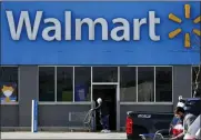  ?? ASSOCIATED PRESS FILE PHOTO ?? A woman pushes a shopping cart to enter a Walmart in Rolling Meadows, Ill.