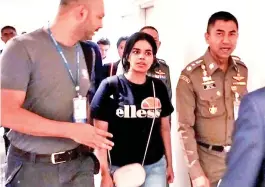  ?? — Gambar AFP ?? Gambar serahan ini yang diambil dan dikeluarka­n oleh Biro Imigresen Thailand pada 7 Januari lepas menunjukka­n Qunun (tengah) diiringi seorang pegawai imigresen Thai (kanan) dan pegawai UNHCR di Lapangan Terbang Antarabang­sa Suvarnabhu­mi di Bangkok, Thailand.