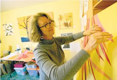  ?? JANE TYSKA/STAFF ?? Freelance artist Robin Schreiber works Tuesday at her studio in Belmont. Schreiber, an Oakland native, has become known as the Golden StateWarri­ors “Dance Cam Mom” after a video of her dancing in an ugly sweater at a November Warriors game went viral,...