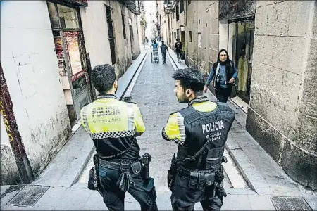  ?? XAVIER CERVERA ?? Dos agentes de la Guardia Urbana durante la operación policial llevada a cabo ayer en la calle Riereta