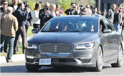  ?? JULIE OLIVER ?? David van Geyn, right, from Blackberry QNX, holds up his hands to demonstrat­e the driverless car test, with Ottawa Mayor Jim Watson, left, and others joining the ride Thursday in suburban Ottawa. It was touted as the first street test of an autonomous...