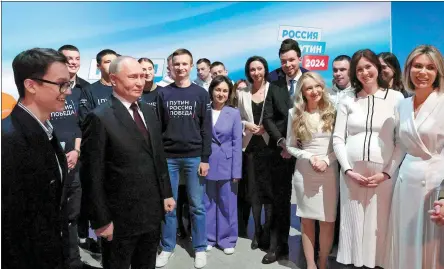  ?? MIKHAIL METZEL / SPUTNIK VIA AFP ?? Russian President Vladimir Putin (front, second from left) meets on Sunday with his supporters and volunteers at his campaign headquarte­rs in Moscow.