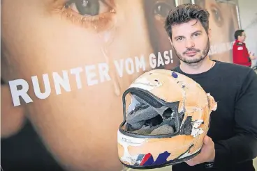  ?? FOTO: DPA ?? Til Schwartz hat seinen Bruder durch einen Motorradun­fall verloren. Den zerstörten Helm hat er verwahrt und hält ihn während der Präsentati­on der Kampagne „Runter vom Gas“in den Händen.