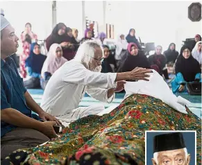  ??  ?? Farewell, old friend: A. Samad taking a last look at Dr Shahnon (inset) before the solat jenazah at Surau Al-Madani in Bandar Baru Bangi. — Bernama