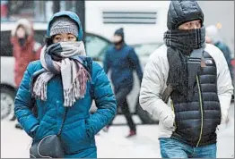  ?? CJ GUNTHER/EPA ?? Pedestrian­s in Boston bundle up against low temperatur­es on Saturday.